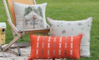 3 pillows displayed on a chair and blanket outside