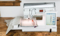 A sewing machine creating a feather design